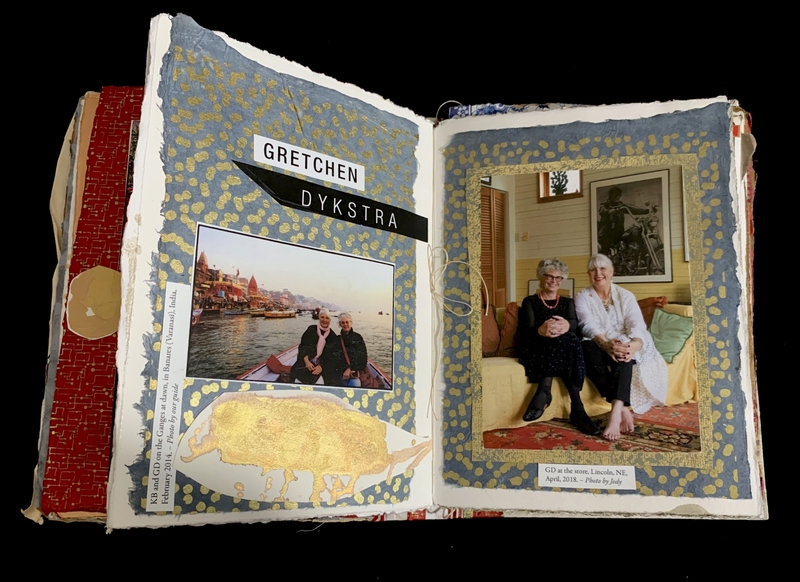 Open scrapbook with travel and indoor photos, decorated with blue and gold patterns.