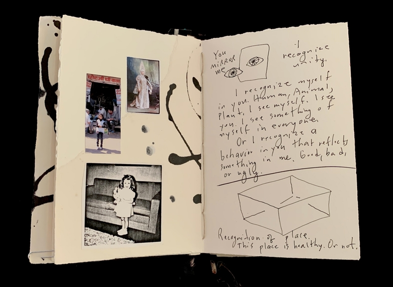 Open notebook with photos, ink drawings, and handwritten text on pages.
