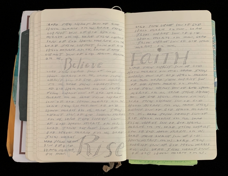 Open notebook with pages covered in handwritten text and words "Believe" and "FAITH" prominently displayed.