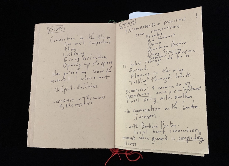 Open notebook with handwritten essays discussing divine connection and friendships.