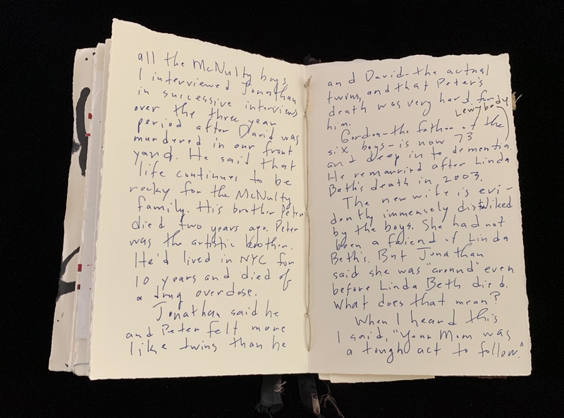 An open notebook with handwritten text in blue ink on both visible pages.