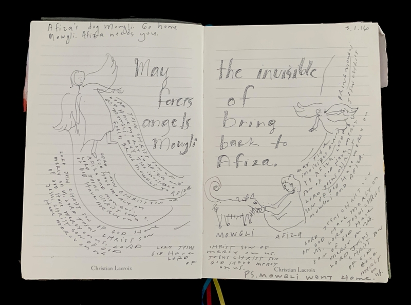 Open journal with handwritten text and drawings of angels and figures