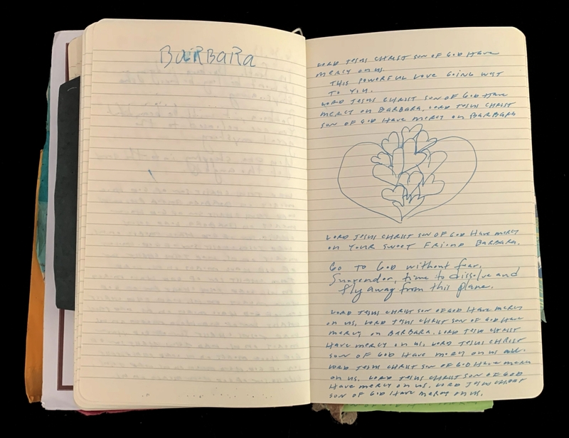 Open notebook with handwritten text and a heart drawing on the right page.