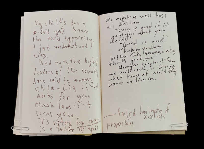 Open notebook with handwritten text on two pages.