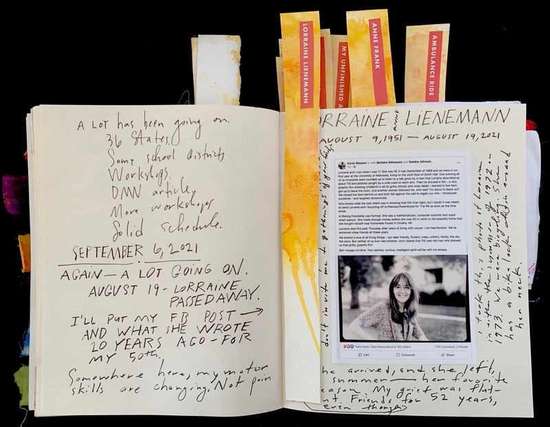 Open journal with handwritten text and a tribute to Lorraine Lienemann, including a photo and bookmarks titled "LORRAINE LIENEMANN," "ANNE FRANK," "MY UNFINISHED," and "AMBULANCE RIDE."