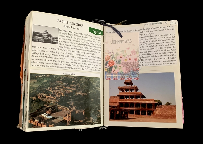 Open book showing pages with text and images about Fatehpur Sikri, including an aerial view and an ornate red stone building, with a decorative card stating "JOHNNY WAS."