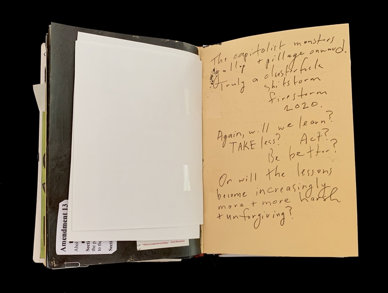 A handwritten note on a yellowed page within a folder, discussing societal and environmental concerns.