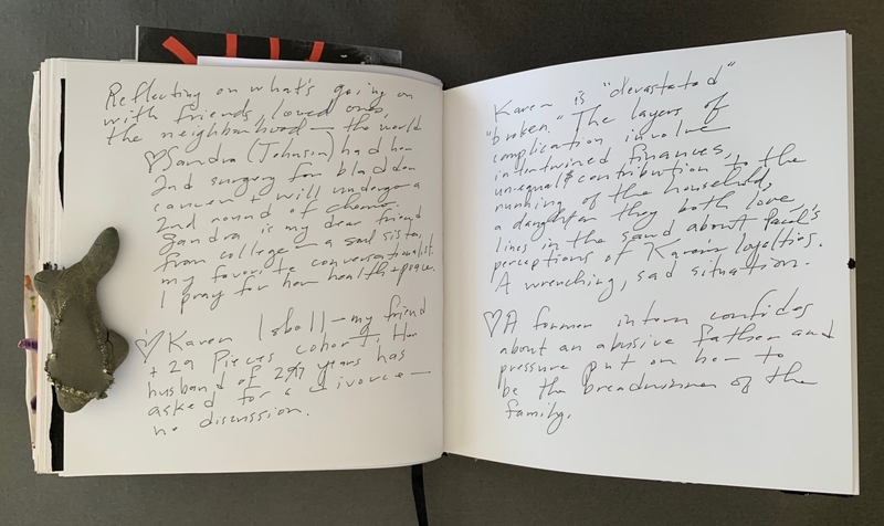 A handwritten journal page with notes and a small stone decoration.