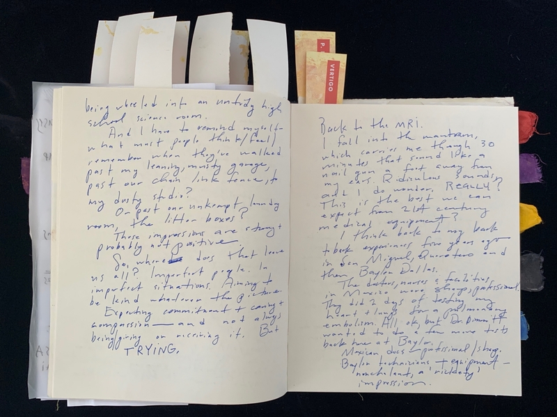 Open journal with handwritten text and colorful tab markers.