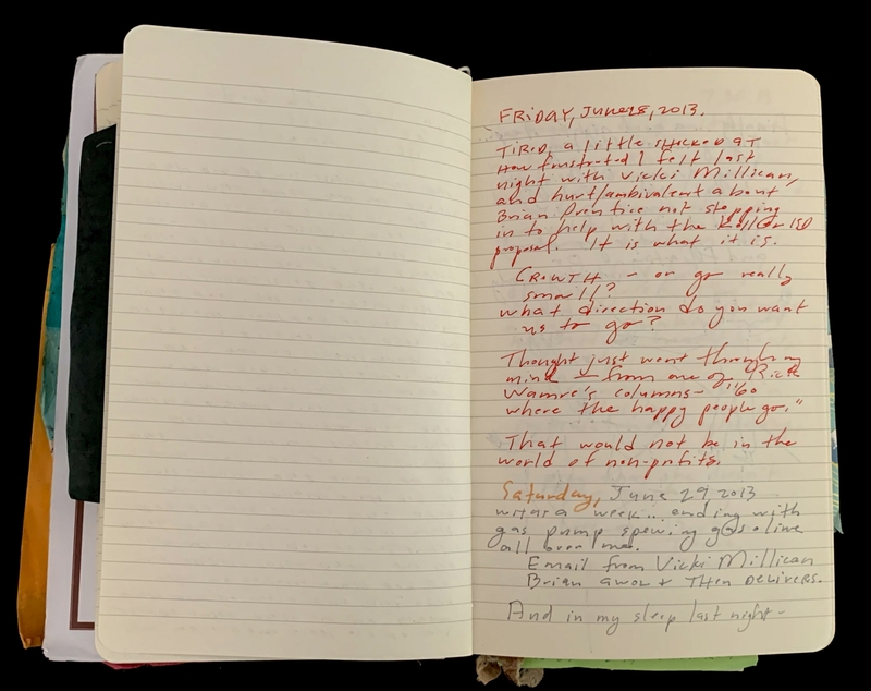Open notebook with handwritten notes in red and black ink.
