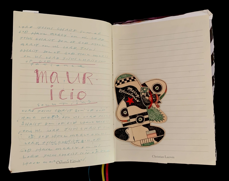 An open journal with handwritten text and a decorative holiday-themed cut-out.