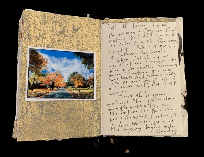 Open book with a textured golden page featuring an autumn photograph and a page of handwritten text.