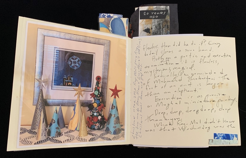 An open scrapbook with art and handwritten text, featuring a winter scene and cone-shaped decorations.