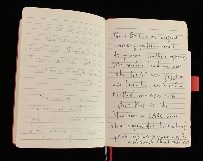Open notebook with handwritten text on cream-colored pages.