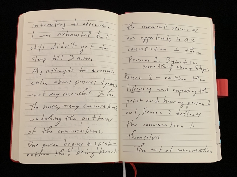 Open notebook with handwritten text on two pages.