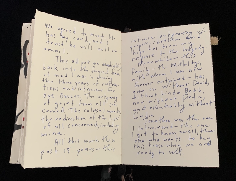 Open notebook with handwritten text filling both pages in blue ink.