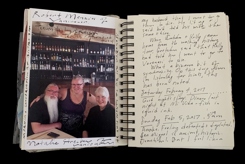 A handwritten journal entry with a photograph of three individuals at a bar, accompanied by notes about a trip to Varanasi.