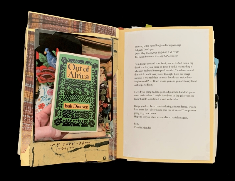 A photograph of a book titled "Out of Africa" by Isak Dinesen, held in front of a scrapbook page with a handwritten note.