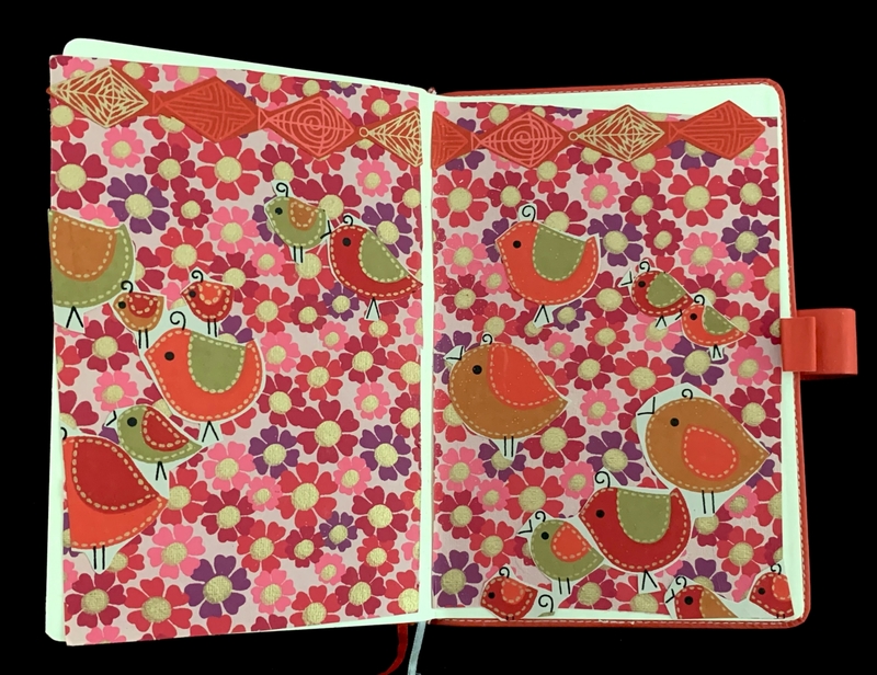 Bright notebook interior with floral and bird illustrations.