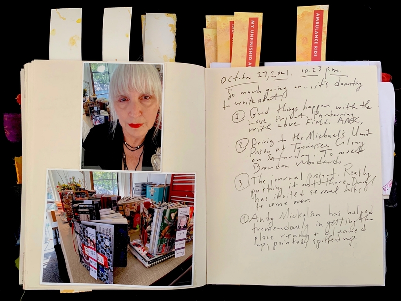 An open journal with photos and handwritten text, marked by colorful tabs.