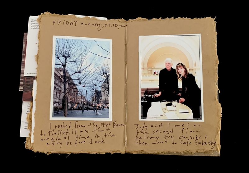An open scrapbook with photos of a city street and two people inside a building, with handwritten notes.