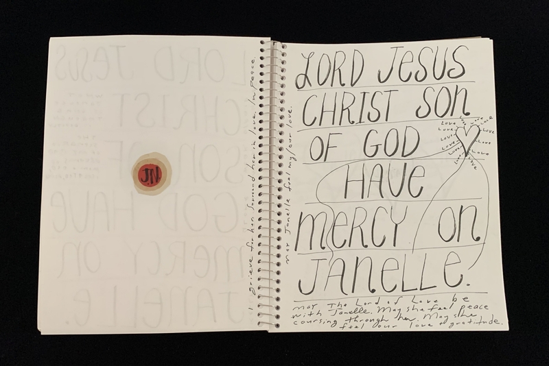 A handwritten prayer page with a red circular sticker and a prayer for Janelle.