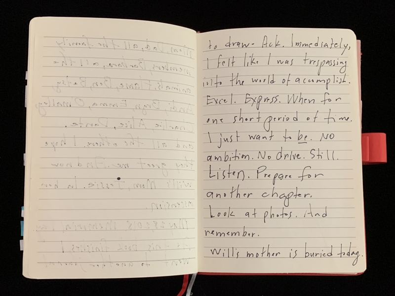 An open notebook with handwritten text on a black background.