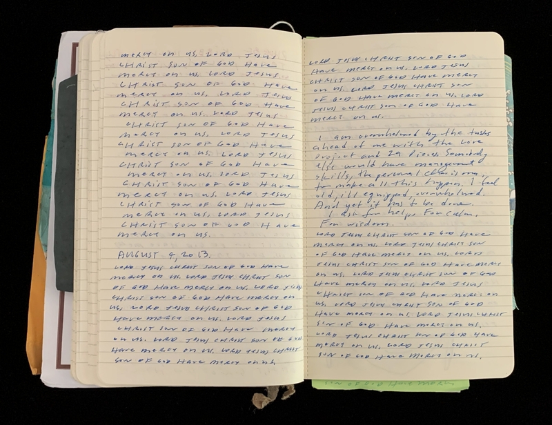Open notebook with handwritten blue ink text on both visible pages.