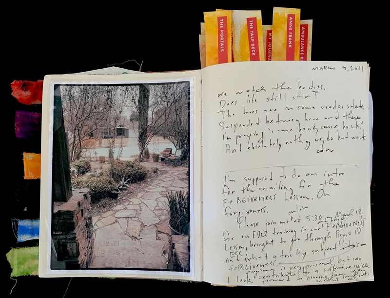An open journal with a photo on the left page and handwritten text on the right. Colorful tabs stick out.