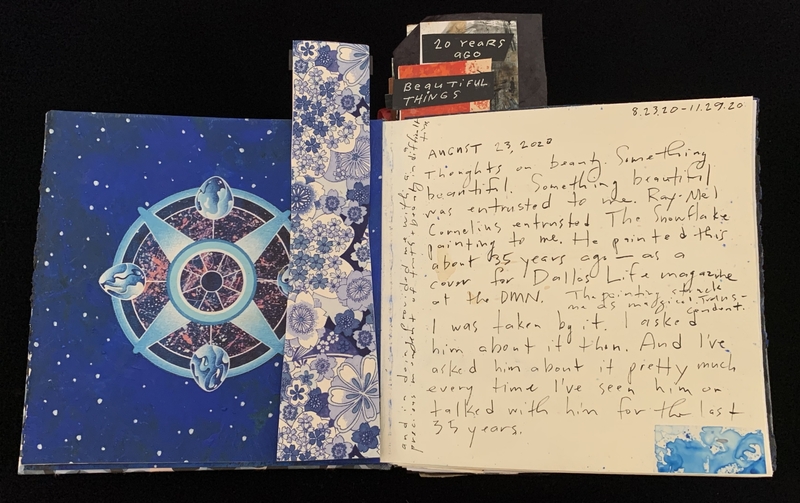 Open journal with cosmic illustration on the left and handwritten text on the right.