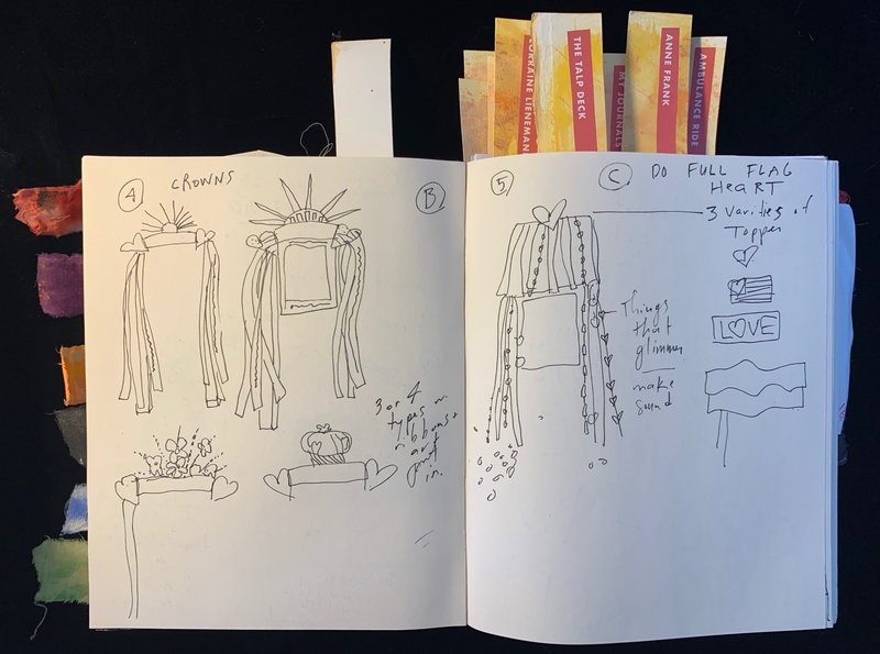 Open journal displaying sketches and handwritten notes with colorful fabric tabs on the side.