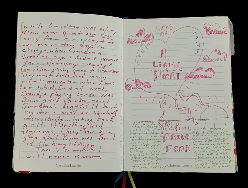 Open journal with handwritten text and colorful artwork on two pages. Left page has personal reflections; right page features a heart with clouds and phrases "A Light Trusting Heart" and "Rising Above Fear."