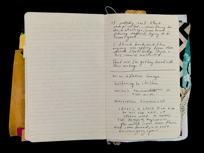 Open notebook with handwritten text on one page and faint writing on the other, with colorful items protruding from the edges.