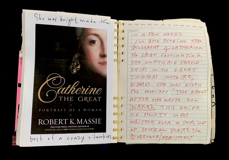 A handwritten note and a book cover are displayed in a spiral-bound notebook.