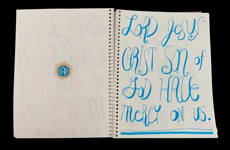 A page from a notebook with handwritten text and a circular sticker.