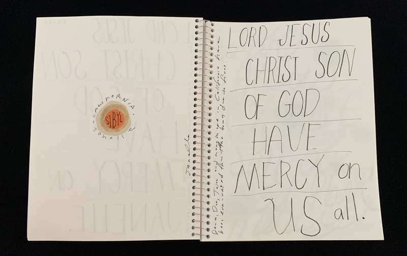 A handwritten prayer page with a circular sticker and faint text.