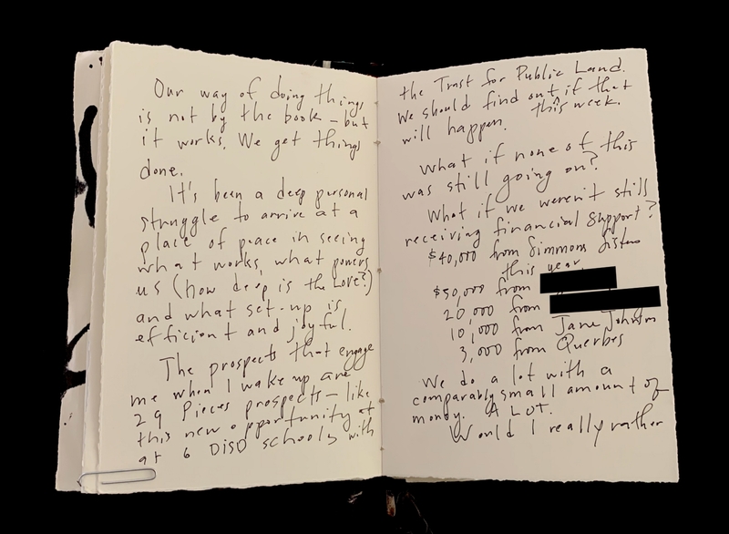Open notebook with handwritten cursive text covering two pages.