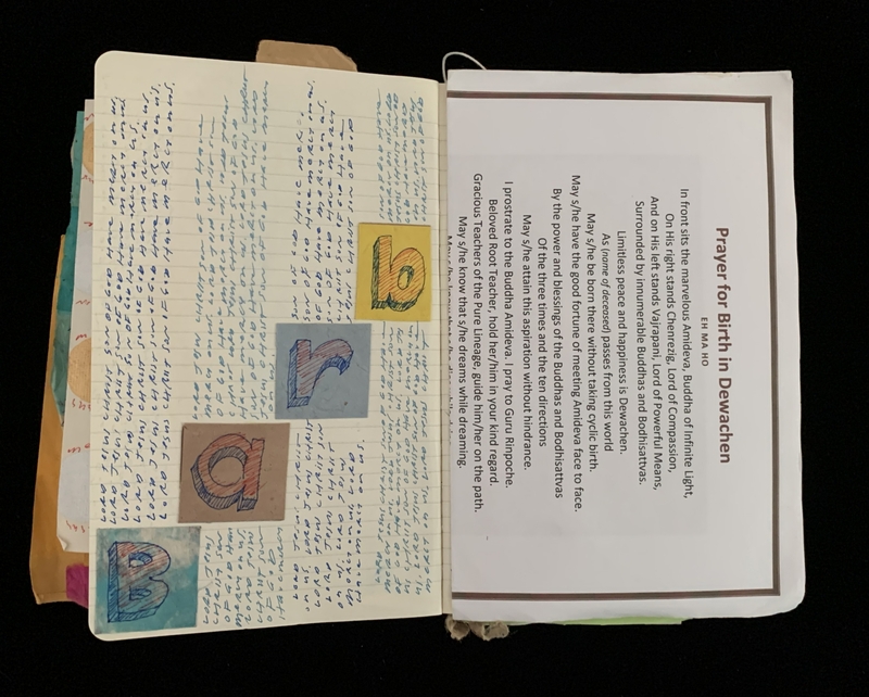 An open notebook with handwritten text on one page and printed text on the other.