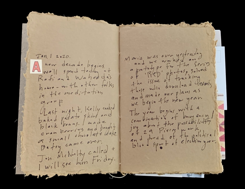 Open notebook with handwritten journal entries dated January 1, 2020.