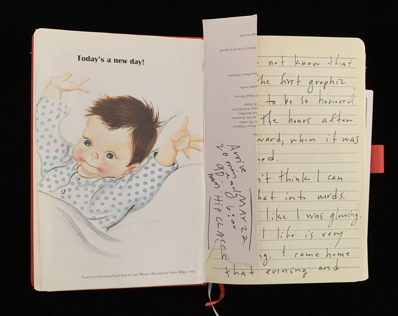 An open book with a baby illustration and handwritten notes on the opposite page.