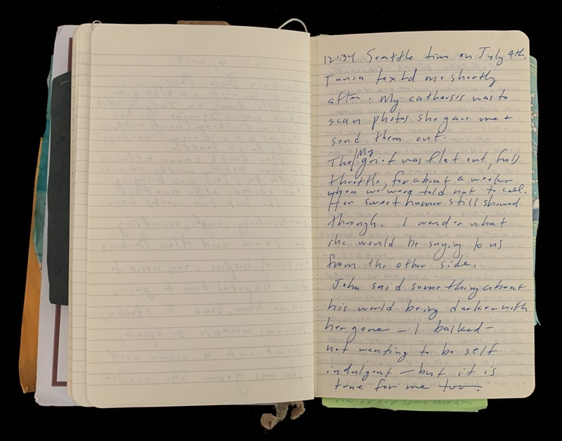 An open notebook showing handwritten text in blue ink.