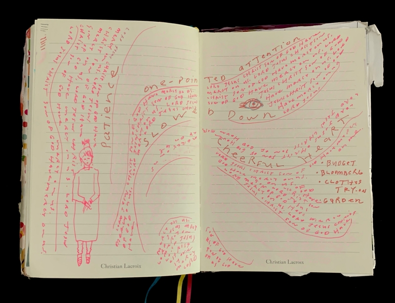 Open journal with red handwriting and artwork, including a drawing of a person and an eye.