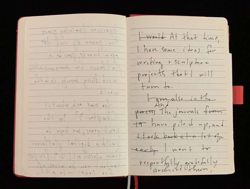 Open notebook with handwritten text on two pages, one page upside down.