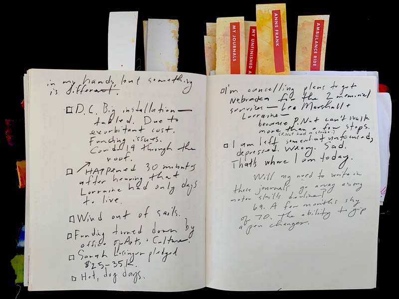 Open journal with handwritten text and colorful ribbon bookmarks.