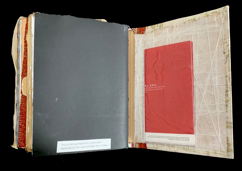 Open book with a dark gray page on the left and a translucent cover with a red insert on the right.