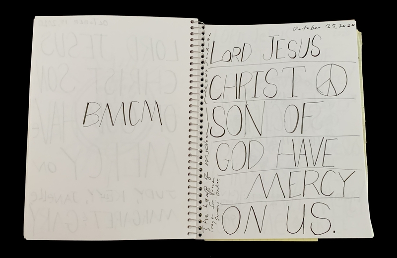 A handwritten page with religious text and a peace symbol.