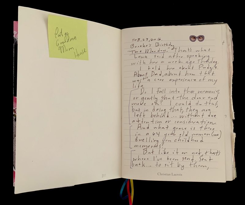 Open journal with handwritten notes on one page and a sticky note on the other.