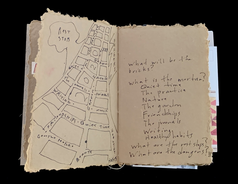Open journal with a hand-drawn map on the left page and handwritten notes on the right page.