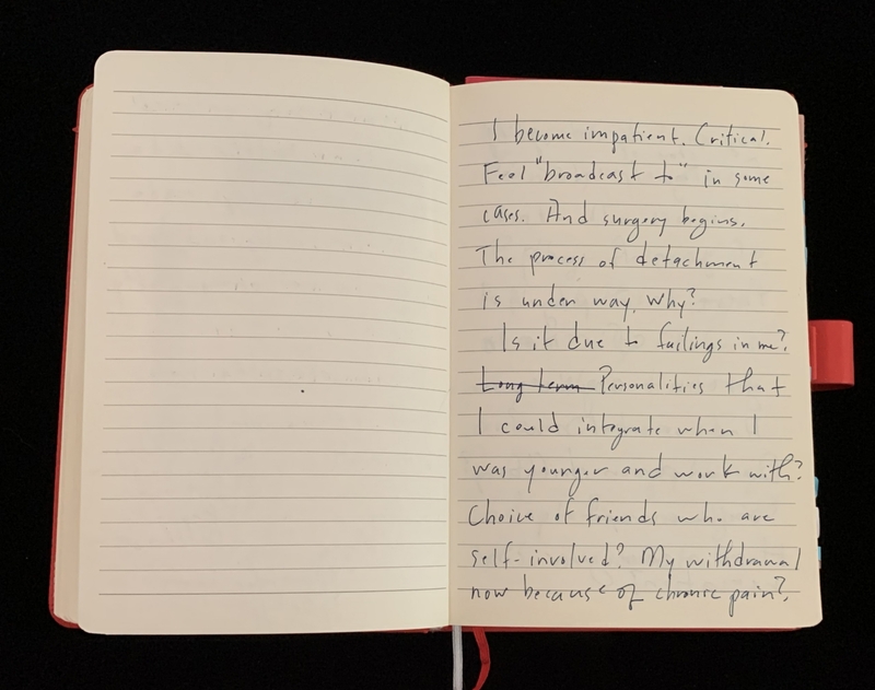 Open notebook with handwritten text on one page and a blank lined page on the opposite side.