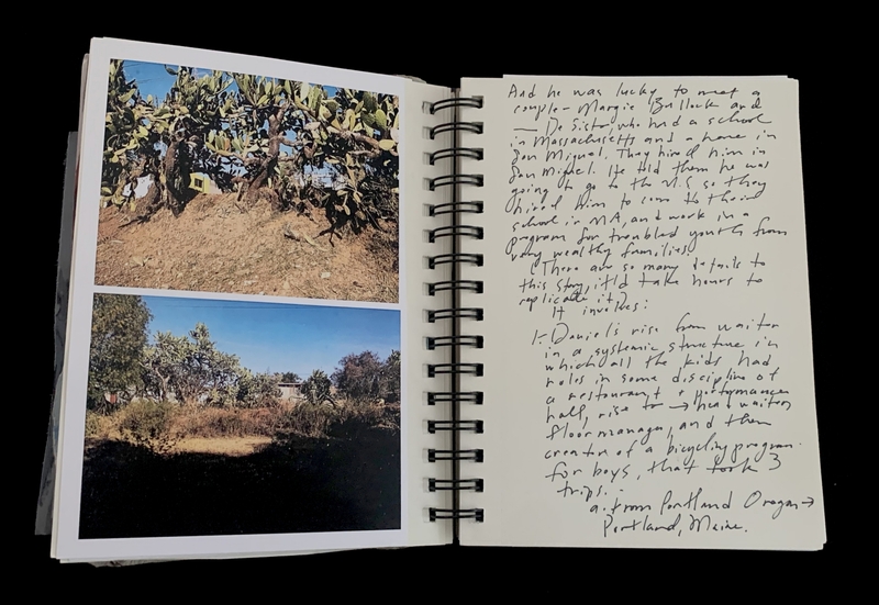 A handwritten note in a spiral-bound notebook accompanied by two photographs of desert landscapes.